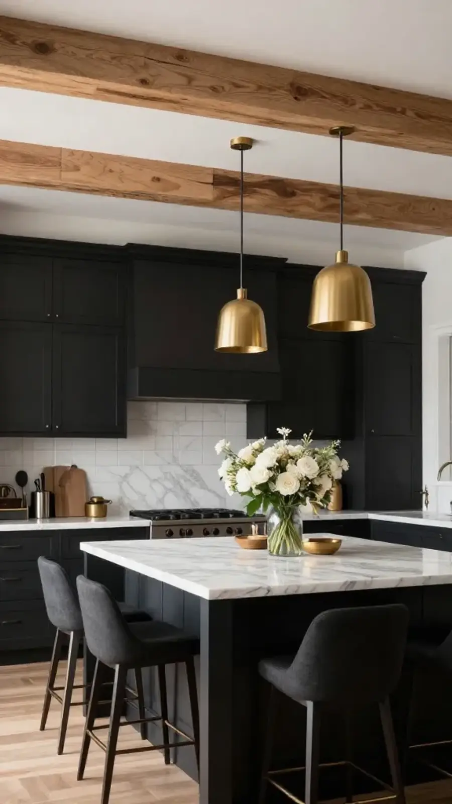 A modern kitchen with dark cabinets, a marble island, and elegant lighting.